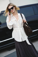 White belted linen-blend blouse with roll-tab sleeves and front pockets, shown on-model outdoors front view