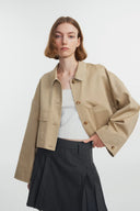 Earth tone cotton-blend jacket with boxy fit, button front, patch pockets, and contrast stitching, front view on model.