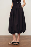 Brownish red cotton-blend bubble skirt with gathered hem and side pockets, front view on model standing indoors