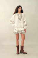 Ensemble blouse et jupe en coton froissé avec broderie, lien à pompons perlés et finition torsadée