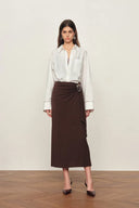White cotton shirt with openwork trim on cuffs, relaxed fit, front view on model standing against plain background