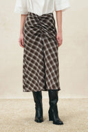 Earth tone plaid skirt with front ruching, V-shaped waistband and split hem, front view on model