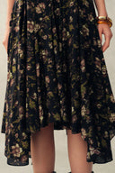 Black viscose floral dress skirt with ruffle hem and handpainted details, close-up front view on model