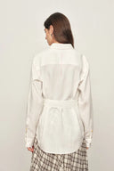 Back view of white belted blouse in linen blend with roll tab sleeves and subtle back seam detail