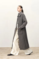 Model wearing a grey longline merino wool blend cardigan with cable knit texture and sailor collar over white trousers