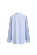 Back view of pale blue cotton shirt with openwork trim on cuffs from Fabrique Tops collection