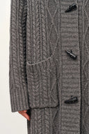 Grey cable knit cardigan with mixed textures patch pocket and horn buttons