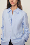 Light blue cotton blouse with openwork trim on cuffs, relaxed fit, front view, Fabrique collection.