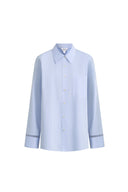 Pale blue cotton blouse with openwork trim on cuffs, oversized silhouette, front button closure, front pocket detail