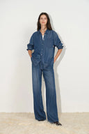 Front view of a blue lyocell denim shirt with relaxed fit and pocket detail, styled with matching denim pants.