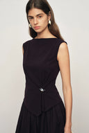 Sleeveless dark purple top in cotton blend with twisted drape and silver-tone pin detail, front view on model