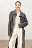 Model wearing a grey longline cable knit cardigan with sailor collar and horn buttons