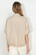 Back view of khaki bubble puff sleeve shirt with dropped shoulders and softly curved hem on model