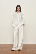 White cotton relaxed shirt with openwork trim on cuffs and front pocket, shown front view on model