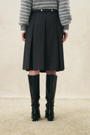 Black belted pleated midi skirt styled with a striped sweater and knee high boots