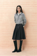 Black belted pleated midi skirt styled with a gray striped sweater and knee high boots