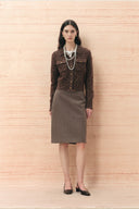 Model wearing a cropped brown wool blend cardigan with gold buttons and a brown midi skirt