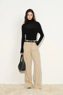Model wearing warm khaki wide leg womens jeans with curved pockets and a black top