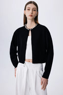 Black lyocell-wool blend knit cardigan with pearl embellishments along neckline, front view on model.