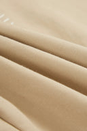 Close-up detail of earth tone cotton-blend fabric showing fine woven texture and subtle folds.
