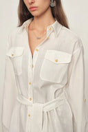 White linen-blend belted blouse with roll tab sleeves, flap pockets, and button-down front, front close-up view