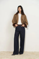 Model wearing dark indigo straight leg womens jeans with a contrast tan faux suede waistband
