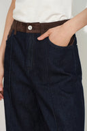 Women's dark indigo straight leg jeans with a warm tan faux suede waistband and front pocket