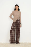 Model wearing wide leg plaid pants with a layered waistband and relaxed tailored fit