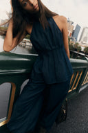 Woman wearing a dark denim halter neck top and wide leg jeans matching set
