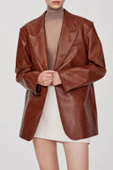 Earth tone eco wax leather blazer with notch lapel and welt pocket, front view on model from waist up.