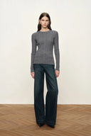 Gray fitted ribbed Merino wool knit top with long sleeves and side slits, styled with dark wide leg jeans