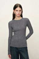 Model wearing a gray fitted Merino wool knit top with long sleeves and side slits