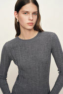 Woman wearing a fitted grey wool knit top with long sleeves and ribbed texture