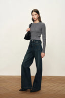 Gray fitted ribbed wool knit top with long sleeves styled with wide leg dark jeans and a black shoulder bag