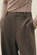 Brown straight leg wool blend pants with a metal ring waist detail and tailored seam lines