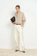 Khaki bubble puff sleeve shirt with dropped shoulders, paired with white wide-leg pants, front view on model.