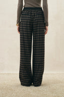 Dark plaid flannel wide leg pants with a drawstring waist on a model