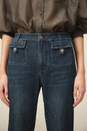 Women's dark washed denim jeans with a high waist and buckled flap pockets