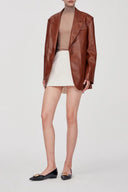 Earth tone eco wax leather blazer with dropped shoulders and single button, front view on model.