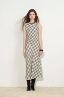 Model wearing a grey checked seersucker midi dress with a sculpted bias cut silhouette and black boots