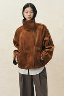 Model wearing a caramel oversized vegan suede jacket with batwing sleeves, high collar and leather trim