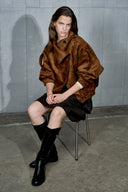 Model wearing a caramel vegan suede oversized womens jacket with batwing sleeves and leather trim