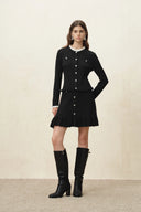 Black knit cardigan with button front and scalloped ruffled hem, styled with knee high boots