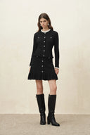 Black scalloped crochet cardigan with button front styled with a ruffled skirt and knee high boots