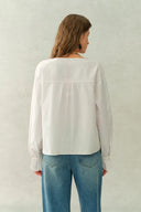 Back view of a white crinkle cotton blouse with long sleeves and gathered cuffs
