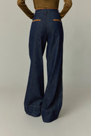 Back view of high waisted wide leg women's jeans in dark cotton denim with contrast pocket trim