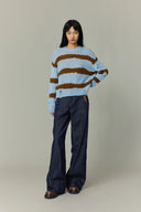 Model wearing high waisted wide leg dark denim jeans with contrast trim
