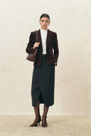 White ruffle trimmed fitted turtleneck top styled with a burgundy blazer and black midi skirt