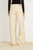 Cream wide leg pants with rear pockets and curved seam detailing on the legs