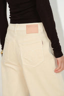 Rear view of cream wide leg corduroy pants with tonal back pocket embroidery